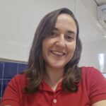 Foto da servidora: blusa vermelha, cabelo liso e com comprimento um pouco abaixo dos ombros